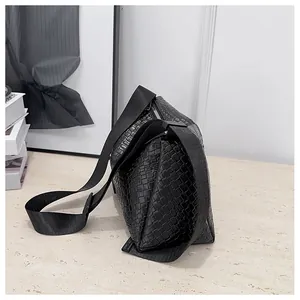 Détail rapproché de la texture en cuir tressé noir et de la bandoulière du grand sac