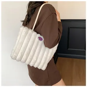 Detail of white faux fur tote bag with vertical stripes and purple logo patch
