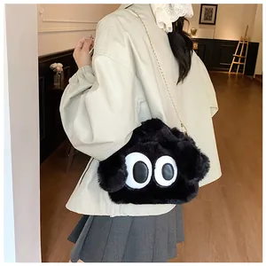 Détail du sac en peluche noir mignon avec de grands yeux et chaîne dorée