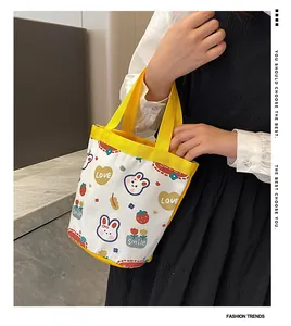 Detail of a small canvas tote bag with yellow handles featuring cute cartoon rabbit prints