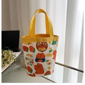 Détail du sac seau en toile avec imprimé tigre et anse jaune pour déjeuner ou snacks