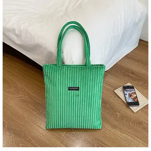 Dettaglio della borsa tote in velluto a coste verdi con trama e logo Fashion