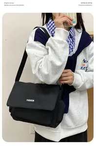 Dettaglio della borsa a tracolla in tela nera con tracolla regolabile e logo moda