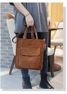 Detail view of brown corduroy tote bag with front snap pocket and adjustable strap