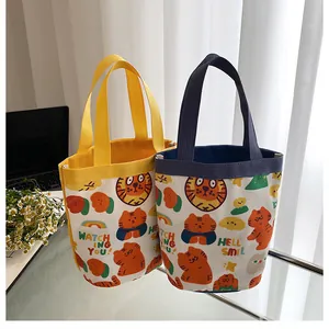 Détail de sacs seaux en toile tigre mignons en jaune et marine sur un bureau