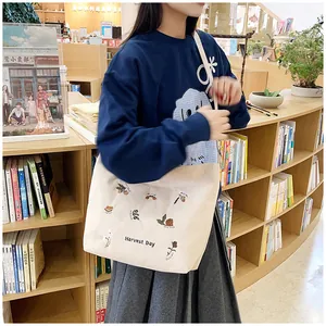 Detail of floral embroidery and Harvest Day text on cream corduroy tote bag