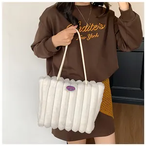 Detail of white plush tote bag featuring vertical stripe texture and purple logo patch