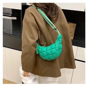 Detail of green quilted cloud crossbody bag with puff texture on female model back