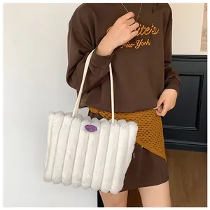 Detailed texture of white plush faux fur tote bag with vertical stripe stitching pattern