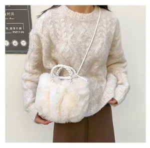 Détail du sac à main en peluche blanche avec fausse fourrure douce et anses tressées