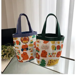 Détail de sacs seaux en toile avec imprimés tigre de dessin animé et anses colorées