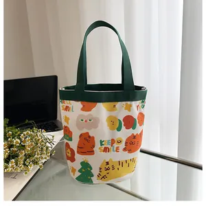 Détail d'un sac seau en toile avec imprimés tigre et poignées vertes sur un bureau