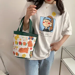 Detail of canvas bucket bag featuring cute cartoon tiger and fruit prints with green handles