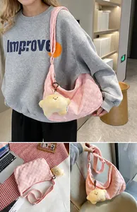 Detailed view of pink quilted waffle shoulder bag with a yellow star plush pendant