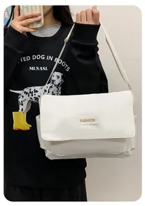 Dettaglio della borsa a tracolla in tela bianca con toppa fashion e tracolla regolabile