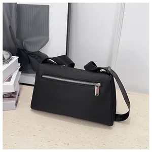Détail du sac bandoulière noir avec poche zippée argentée et sangle large