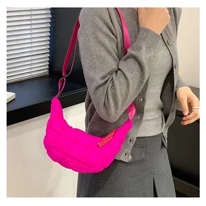 Macro shot of bright pink quilted puff crescent bag with adjustable wide strap for women
