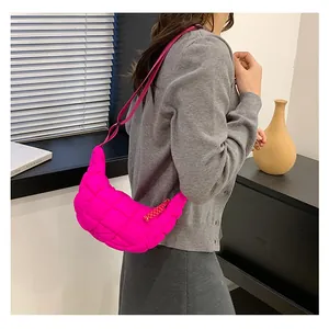 Detail of neon pink quilted puff shoulder bag with adjustable strap and woven zipper pull