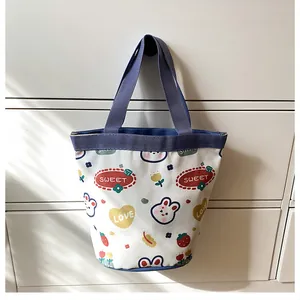 Detail of canvas bucket bag featuring cute rabbit prints and blue handles for daily use