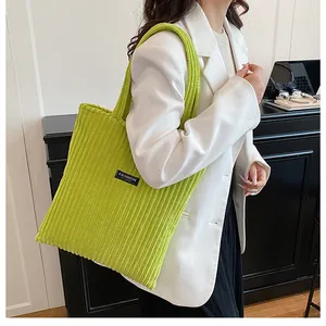 Dettaglio della trama della borsa tote in velluto a coste verde lime con logo FASHION