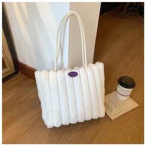 Detail of white faux fur tote bag with vertical quilting and fashion girl patch