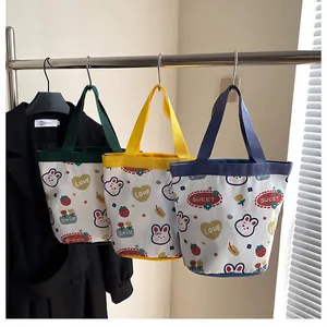 Detailed view of three canvas bucket bags with cute rabbit and strawberry prints