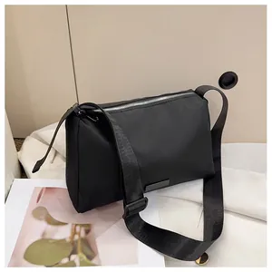 Détail d'un sac à bandoulière en nylon noir avec fermeture éclair argentée chic