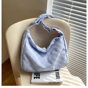 Close-up of light blue waffle-patterned hobo bag featuring a textured weave and silver buckle