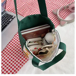 Vue de dessus du sac en toile verte montrant la capacité intérieure et les accessoires
