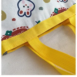 Close-up of sturdy yellow woven handles and reinforced stitching on a canvas tote bag