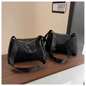 Détail de sacs à bandoulière en nylon et tissés noirs avec fermetures éclair argentées