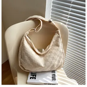 Detailed waffle texture of cream shoulder bag on a chair with artistic lighting