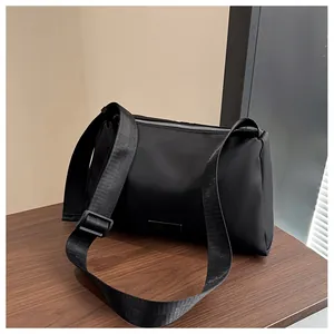 Détail du sac à bandoulière noir avec sangle réglable et fermeture éclair en métal argenté