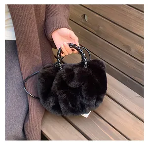Vue détaillée du sac en fausse fourrure noire avec poignée tressée et bandoulière
