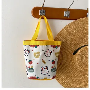 Detail of cute canvas bucket bag with rabbit print and yellow woven handles