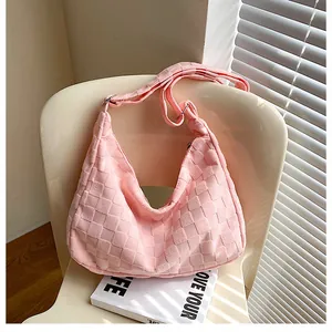 Detail of pink waffle texture crossbody bag resting on chair with soft morning sunlight