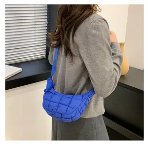 Detail view of bright blue quilted cloud bag with square stitching and crossbody strap