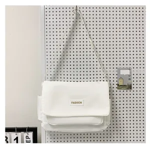 Dettaglio della borsa a tracolla in tela bianca con toppa fashion su pannello