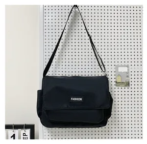 Vista dettagliata della borsa a tracolla in tela nera con etichetta fashion e tasca