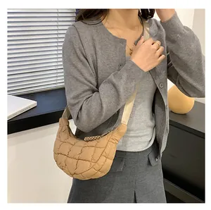 Close-up of khaki quilted crescent bag with adjustable shoulder strap on model