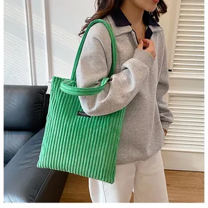 Dettaglio della borsa tote in velluto a coste verdi con texture a coste e etichetta