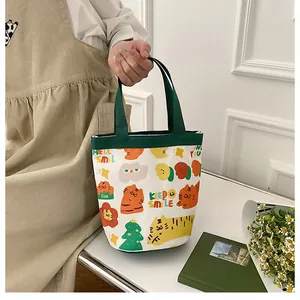 Détail du sac cabas en toile avec imprimés tigre mignons et poignées vertes