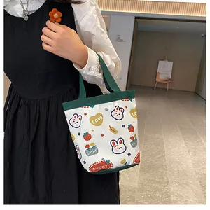 Lifestyle view of a cute cartoon canvas bucket bag with colorful patterns and green handles
