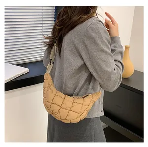 Detail view of khaki quilted puffer moon bag featuring adjustable strap and soft texture