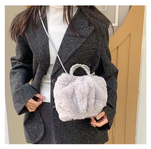 Détail d'un sac bandoulière en fausse fourrure douce avec poignée tissée élégante