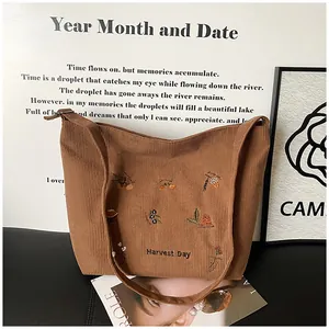 Close-up of brown corduroy tote bag featuring Harvest Day floral and pinecone embroidery