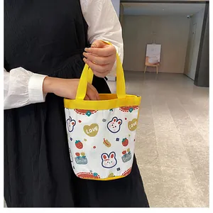 Detail of the yellow handles and cartoon bunny prints on this canvas bucket bag for women