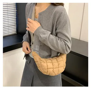 Close-up of khaki puffer crescent bag with quilted diamond pattern and slim strap