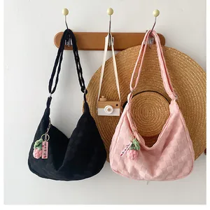 Detail of waffle pattern tote bags in black and pink with strawberry charm pendants