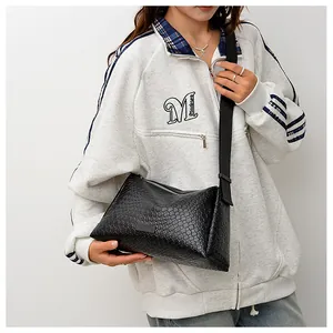 Vue détaillée du sac bandoulière tissé noir avec large bandoulière réglable et texture